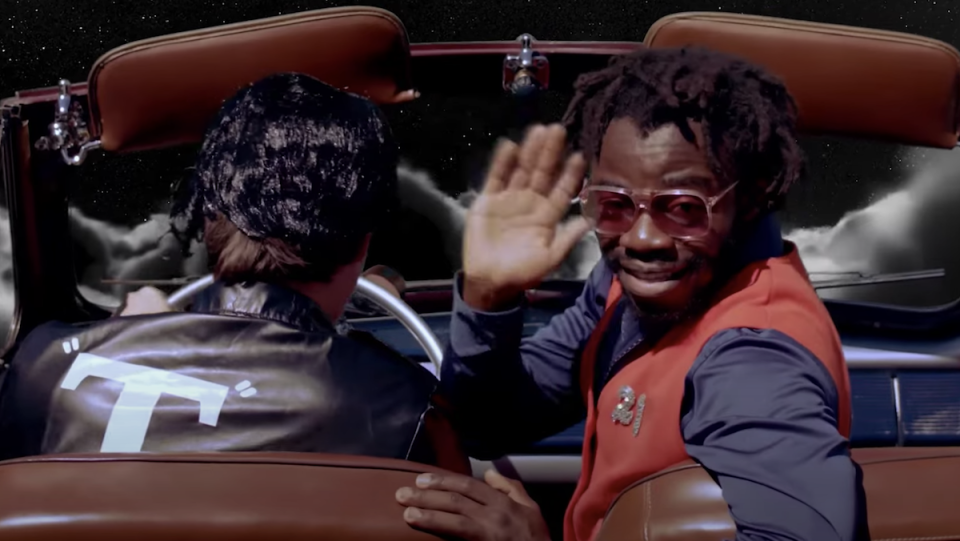 Demi Adejuyigbe waves from the Grease car in his last "September" video.