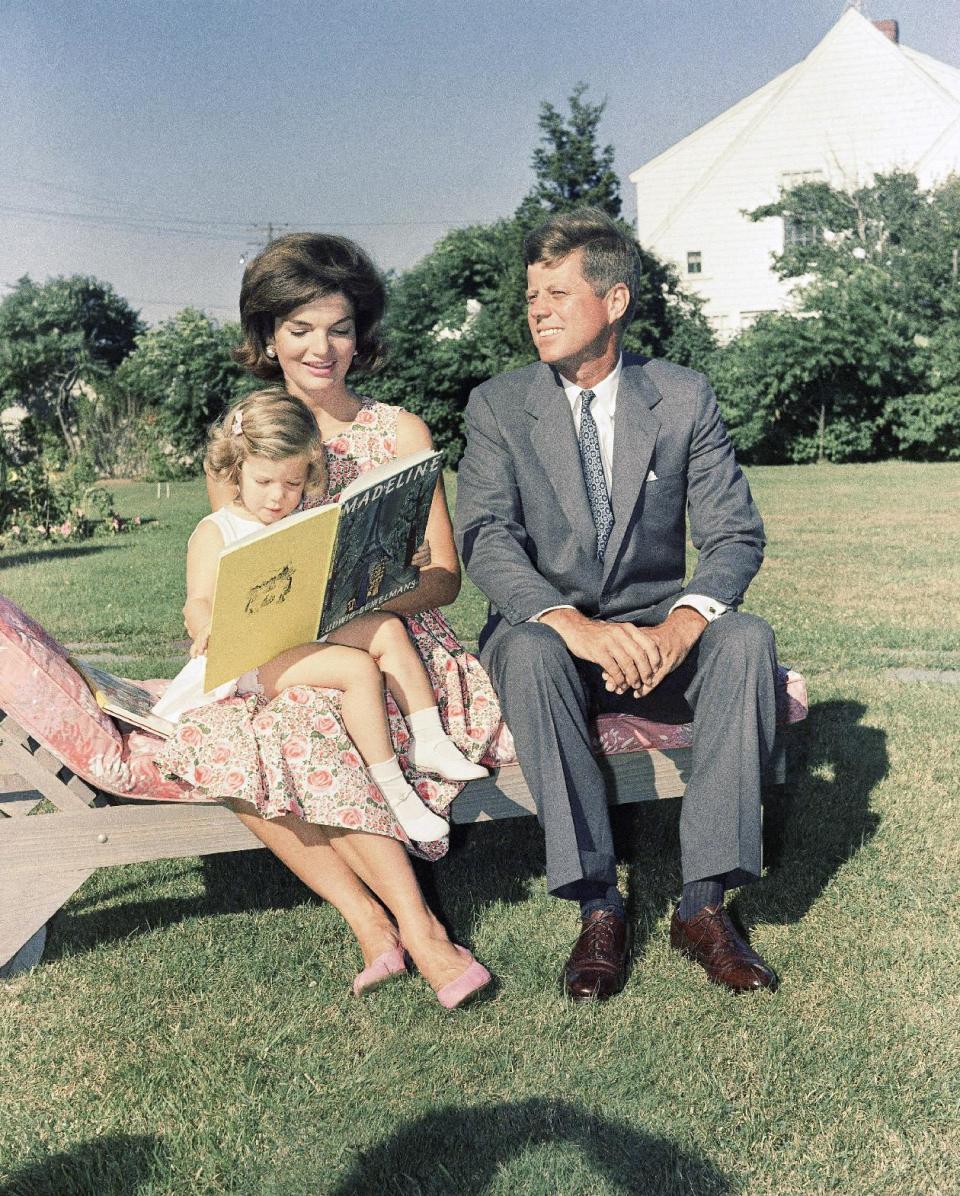 FILE - In this July 25, 1960 file photo , Sen. John F. Kennedy, D-Mass., sits with wife, Jacqueline, as she reads to their daughter, Caroline, at Hyannis Port, Mass. (AP Photo)
