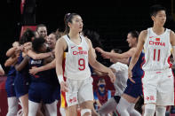 China's Meng Li (9) and Sijing Huang (11) walk off the court as Serbia celebrates their win following a women's basketball quarterfinal game at the 2020 Summer Olympics, Wednesday, Aug. 4, 2021, in Saitama, Japan. (AP Photo/Eric Gay)