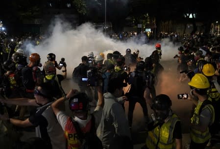 Members of the media react to the tear gas fired by the police in Tuen Mun, Hong Kong