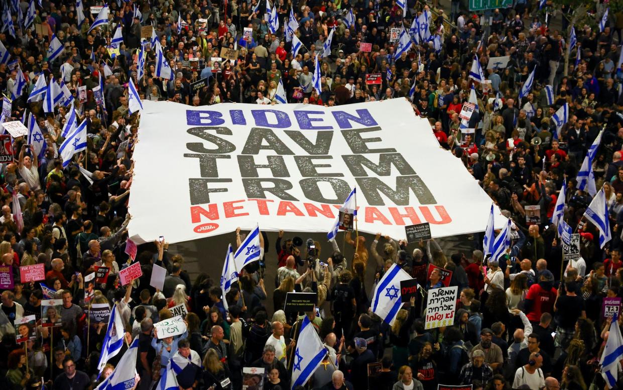 People protest against Israeli Prime Minister Benjamin Netanyahu's government and call for the release of hostages held in the Gaza Strip by the Hamas militant group in Tel Aviv, Israel, Saturday, April 13, 2024. (AP Photo/Ohad Zwigenberg)