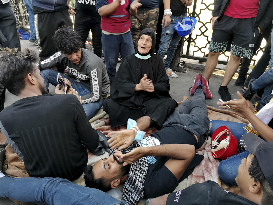 Protesters celebrate while taking control of some concrete walls and barriers installed by security forces to close Sinak bridge leading to the Green Zone government areas, during clashes between Iraqi security forces and anti-government demonstrators in Baghdad, Iraq, Saturday, Nov. 16, 2019. (AP Photo/Hadi Mizban)