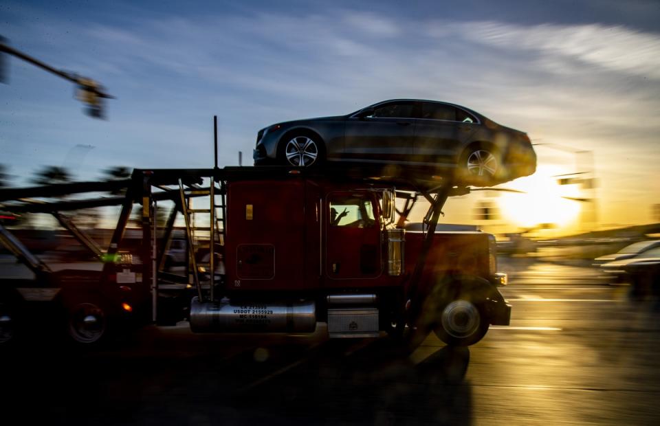 A truck drives past the setting sun