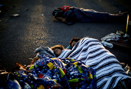 A migrant family, part of a caravan of thousands traveling from Central America en route to the United States, sleeps at a makeshift camp at a gas station where the migrants wait for buses in Navojoa, Mexico November 16, 2018. REUTERS/Kim Kyung-Hoon