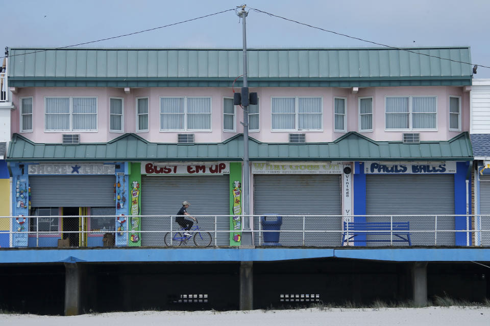 A man rides a bike down the boardwalk, Thursday, May 21, 2020 in Wildwood, N.J. (AP Photo/Matt Slocum)