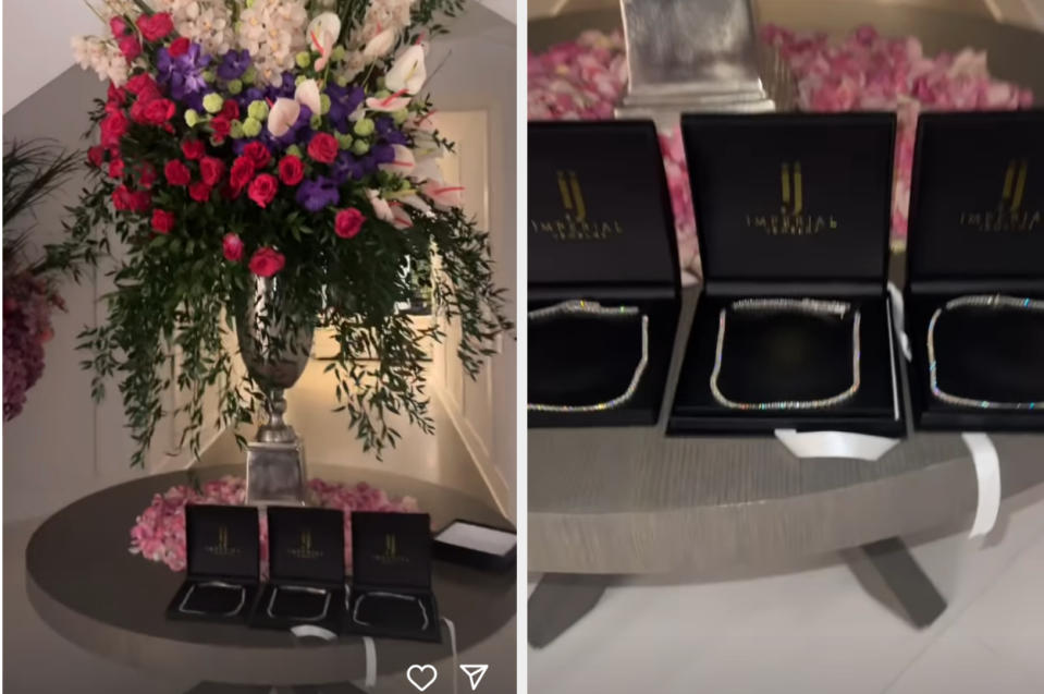 Gift table with floral arrangement and multiple open black boxes displaying jewellery at a celebrity event