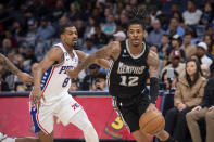 Memphis Grizzlies guard Ja Morant (12) handles the ball ahead of Philadelphia 76ers guard De'Anthony Melton (8) in the first half of an NBA basketball game Friday, Dec. 2, 2022, in Memphis, Tenn. (AP Photo/Brandon Dill)