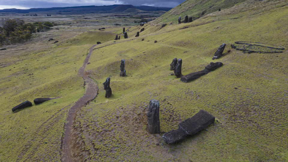 Moai statues stand on the slope of the Rano Raraku volcano on Rapa Nui, or Easter Island, Chile, Sunday, Nov. 27, 2022. Each of them – the nearly 400 on the volcano and more than 500 others elsewhere on the island -- represents an ancestor. A creator of words and music. A protector. (AP Photo/Esteban Felix)