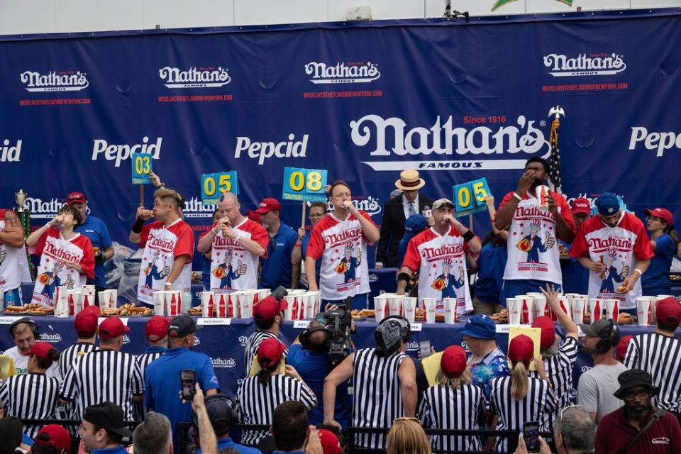 Geoffrey Esper, third from left, couldn't overtake eating superstar Joey Chestnut, center. Esper is from Oxford, Mass.