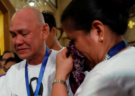 The parents of Kian delos Santos, a 17-year-old student who was shot during anti-drug operations stops grieve during a funeral mass inside a church Caloocan, Metro Manila, Philippines August 26, 2017. REUTERS/Dondi Tawatao