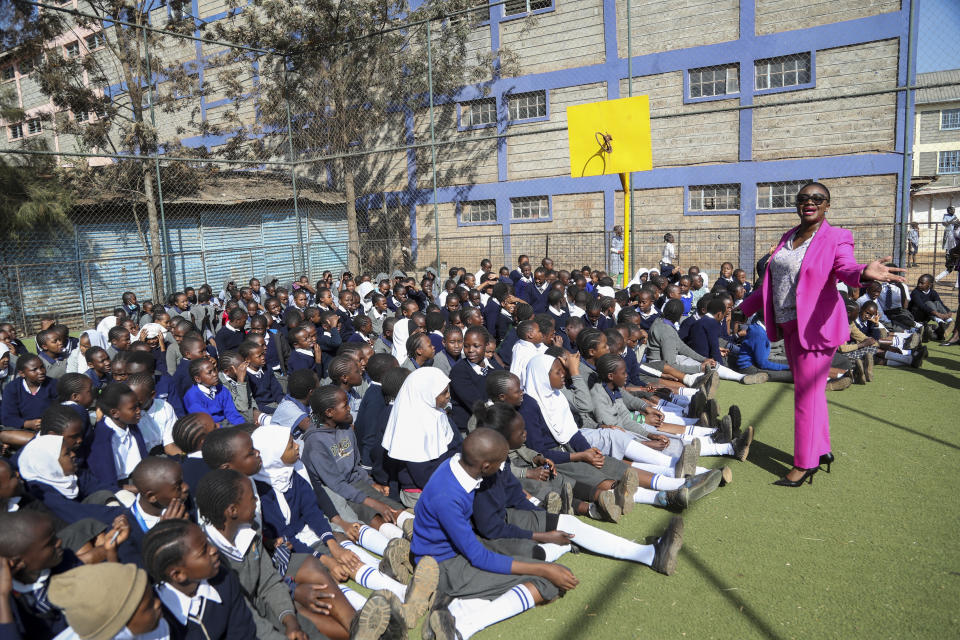 Kenyan senator Gloria Orwoba, right, distributes free sanitary pads to girls at Mukuru Community Center Primary school, while explaining to them the need to openly discuss menstruation to end period shaming, in the Mukuru neighborhood on the outskirts of Nairobi, Kenya, Tuesday, March 7, 2023. Orwoba has said that she attended parliament last month while wearing a white pantsuit stained by her menstruation in order to combat the stigma surrounding women's monthly periods. (AP Photo/Brian Inganga)