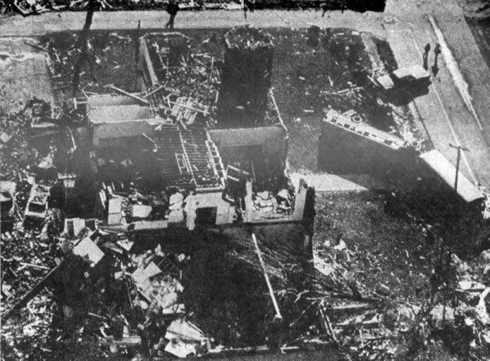 Unbelievably, a large group of Kennard grade school students emerged untouched from beneath their demolished school on April 3, 1974, after a tornado struck the western Henry County community. In this view, looking east, the gymnasium was in the foreground with one ceiling beam still intact, and the other leading against the north side of the structure. The students had been aboard the buses at right before the storm approached.