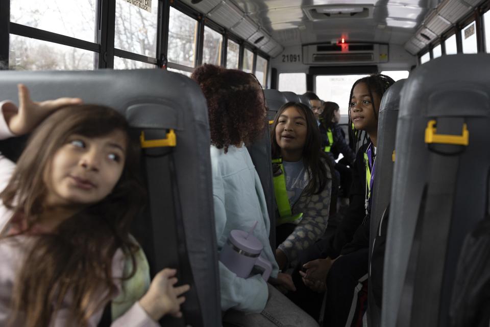 Rock Creek Forest Elementary School students interact while riding an electric school bus, Friday, Feb. 2, 2024, in Chevy Chase, Md. (AP Photo/Tom Brenner)