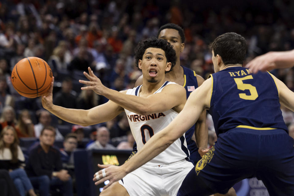 Virginia's Kihei Clark (0) passes the ball while defended by Notre Dame's Cormac Ryan (5) during the second half of an NCAA college basketball game in Charlottesville, Va., Saturday, Feb. 18, 2023. (AP Photo/Mike Kropf)