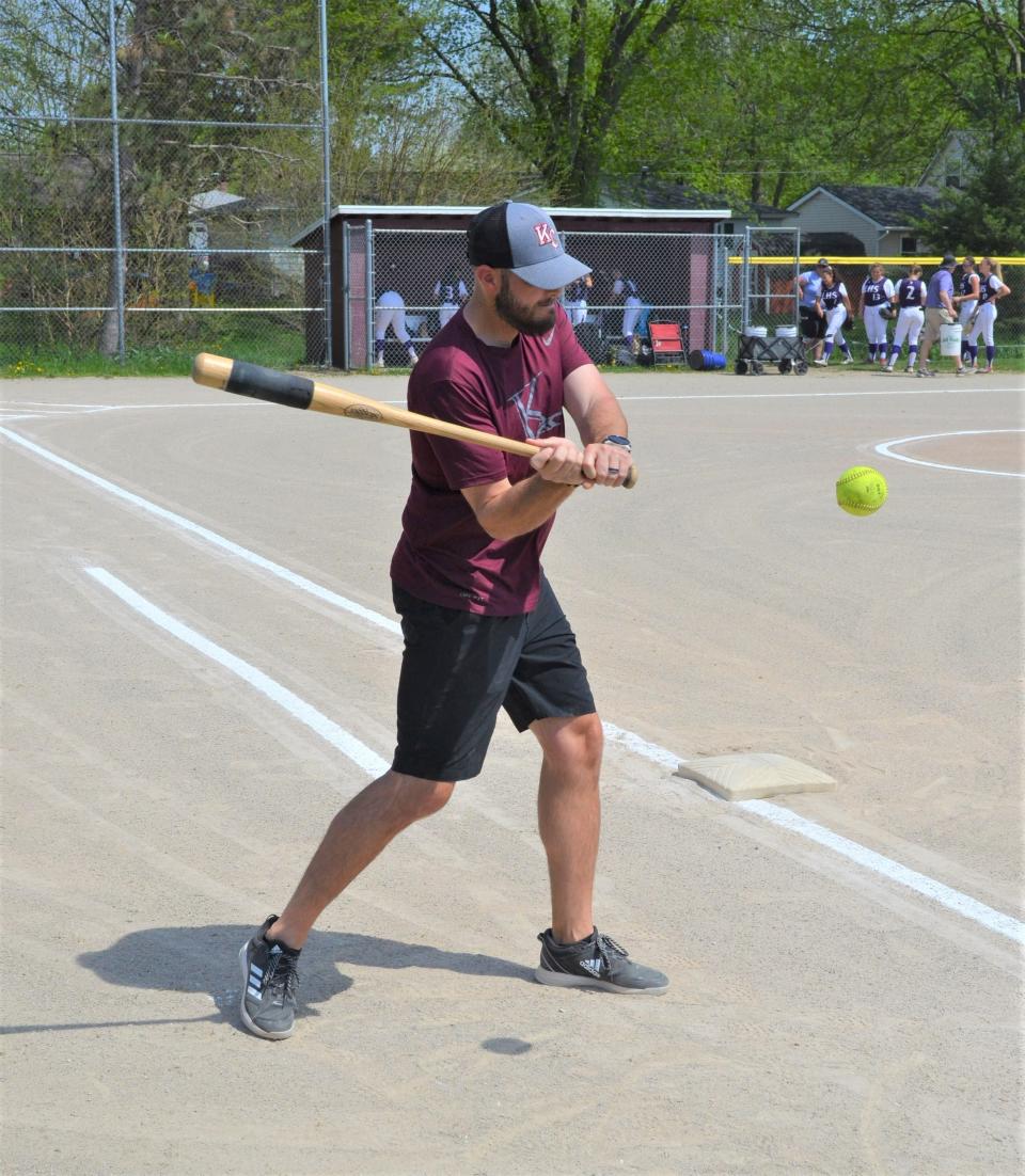 Kalamazoo Central head coach Tyrus Ratliff hits balls to his infield before playing a game against Lakeview, which is coached by his dad Brian Ratliff.