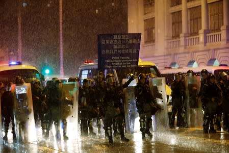 Riot police officers raise a warning flag as they stand guard during a protest in Hong Kong