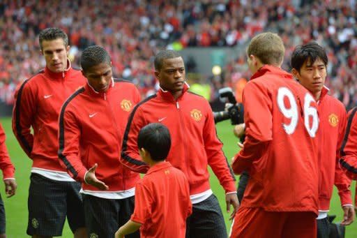 Manchester United defender Patrice Evra (3rd left) waits to shakes hands with Liverpool Steven Gerrard (2nd right)