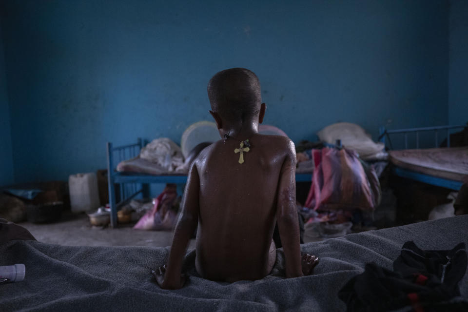 Micheale Gebremariam, un refugiado de Tigray de 5 años, se sienta sobre su cama a primera hora de la mañana, en Hamdayet, en el este de Sudán, cerca de la frontera con Etiopía, el 21 de marzo de 2021. (AP Foto/Nariman El-Mofty)