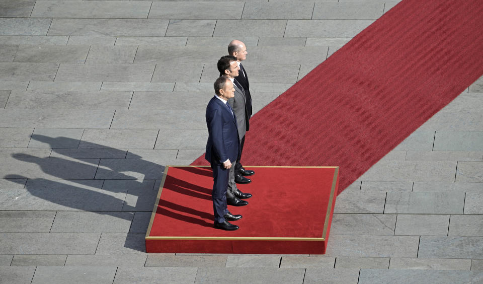 German Chancellor Olaf Scholz, French President Emmanuel Macron and Poland's Prime Minister Donald Tusk, from right, standing at a red carpet for military honors in Berlin, Germany, Friday, March 15, 2024. German Chancellor Olaf Scholz, France's President Emmanuel Macron and Poland's Prime Minister Donald Tusk meet in Berlin for the so-called Weimar Triangle talks. (AP Photo/Markus Schreiber)