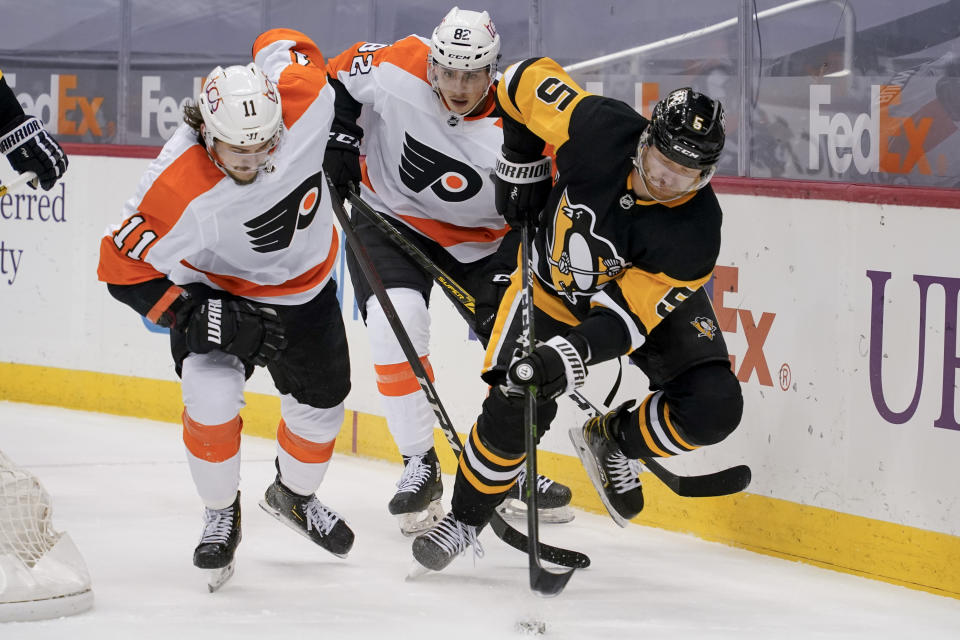 Pittsburgh Penguins' Mike Matheson (5) tries to control the puck as Philadelphia Flyers' Travis Konecny (11) and Connor Bunnaman (82) pursue during the second period of an NHL hockey game, Tuesday, March 2, 2021, in Pittsburgh. (AP Photo/Keith Srakocic)
