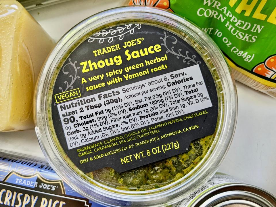 container of trader joe's zhoug sauce in a pile with other groceries