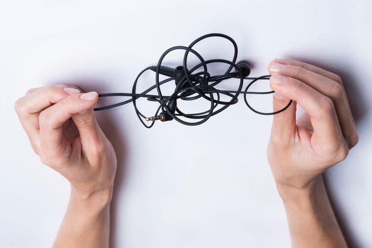 <span class="caption">A knotty problem.</span> <span class="attribution"><a class="link " href="https://www.shutterstock.com/image-photo/female-hands-unravel-black-little-headphones-1184333146?src=_nMmjx-52kYA7yDjzv2OLg-2-54" rel="nofollow noopener" target="_blank" data-ylk="slk:VIKTORIIA NOVOKHATSKA/Shutterstock;elm:context_link;itc:0;sec:content-canvas">VIKTORIIA NOVOKHATSKA/Shutterstock</a></span>