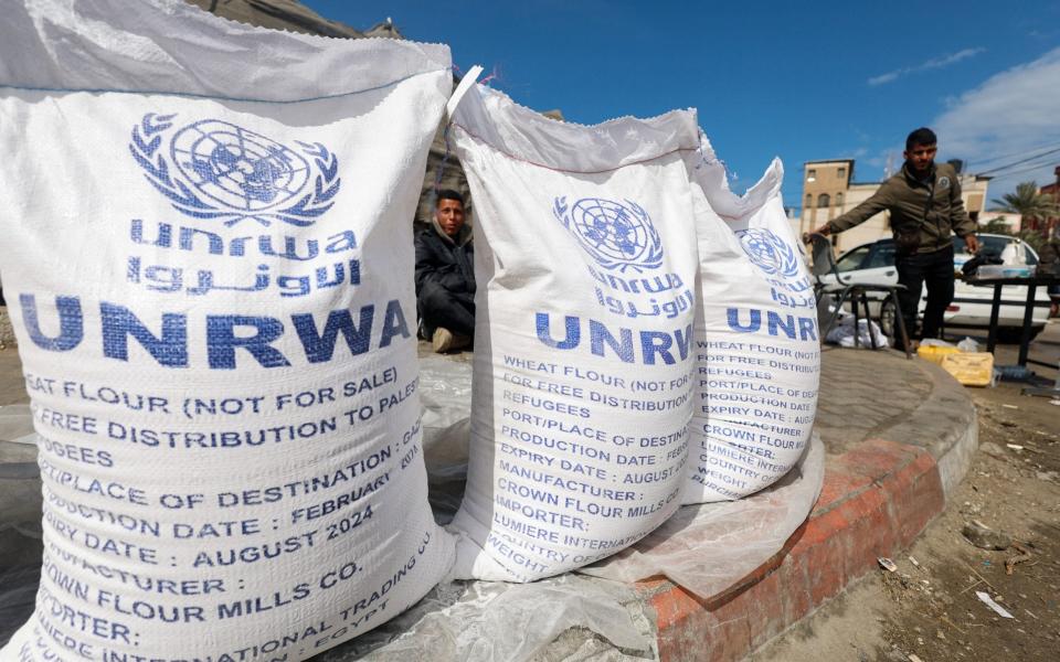 Displaced Palestinians wait to receive United Nations Relief and Works Agency (UNRWA) aid, amid the ongoing conflict between Israel and the Palestinian Islamist group Hamas, in Rafah, in the southern Gaza Strip