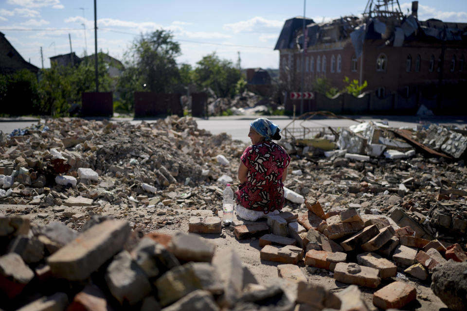 Eine Frau sitzt am Stadtrand von Kiew in den Trümmern (Bild: Natacha Pisarenko/AP/dpa)