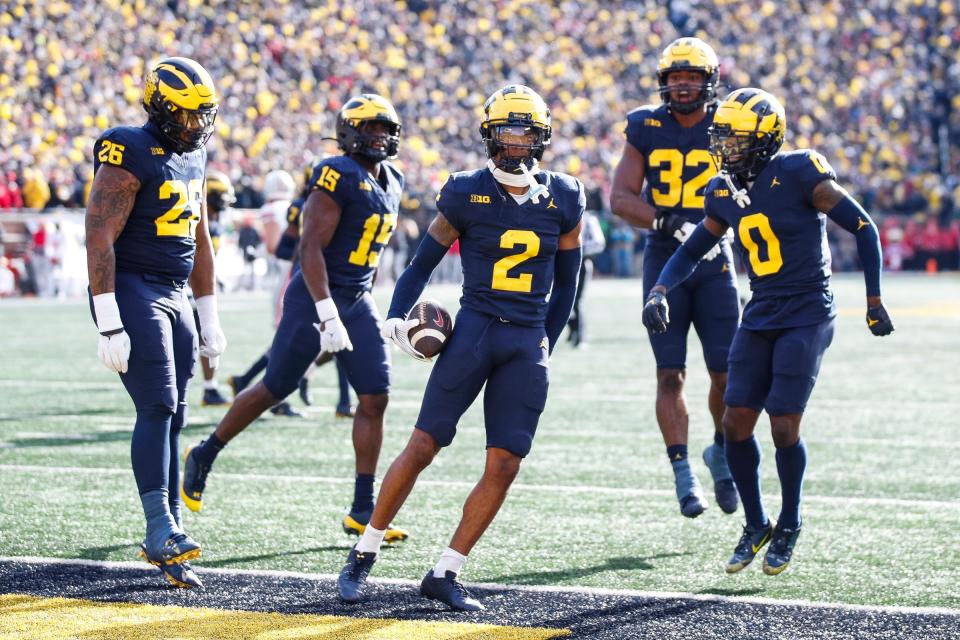 Michigan defensive back Will Johnson celebrates after intercepting a pass from Ohio State quarterback Kyle McCord during the first half at Michigan Stadium in Ann Arbor on Saturday, Nov. 25, 2023.