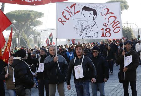 Protesters hold a banner depicting the puppet Pinocchio with the face of Italian Prime Minister Matteo Renzi and reading "Renzi pay attention to the clause 18" during a demonstration against government in downtown Rome December 12, 2014. REUTERS/Remo Casilli