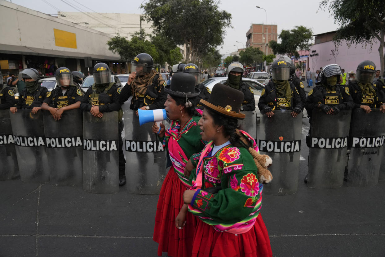 Indigenous anti-government protesters shout in front of a line of police during a march against Peruvian President Dina Boluarte
