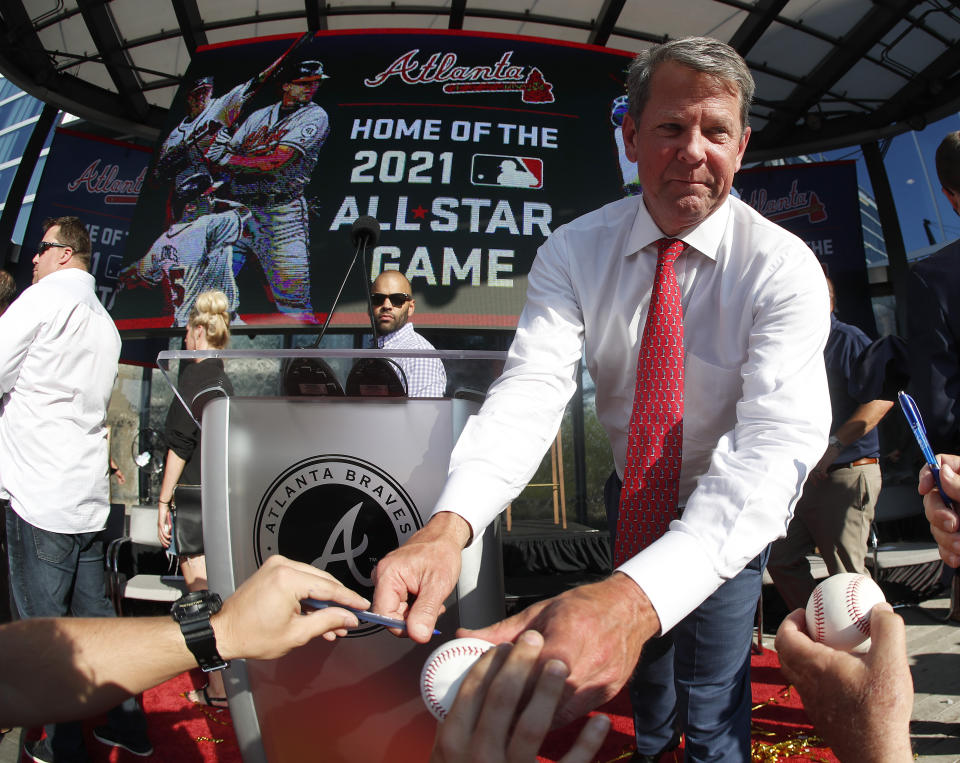 Georgia Gov. Brian Kemp signs a baseball after a ceremony to announce that Atlanta will host baseball's 2021 All-Star Game, Wednesday, May 29, 2019, in Atlanta. (AP Photo/John Bazemore)