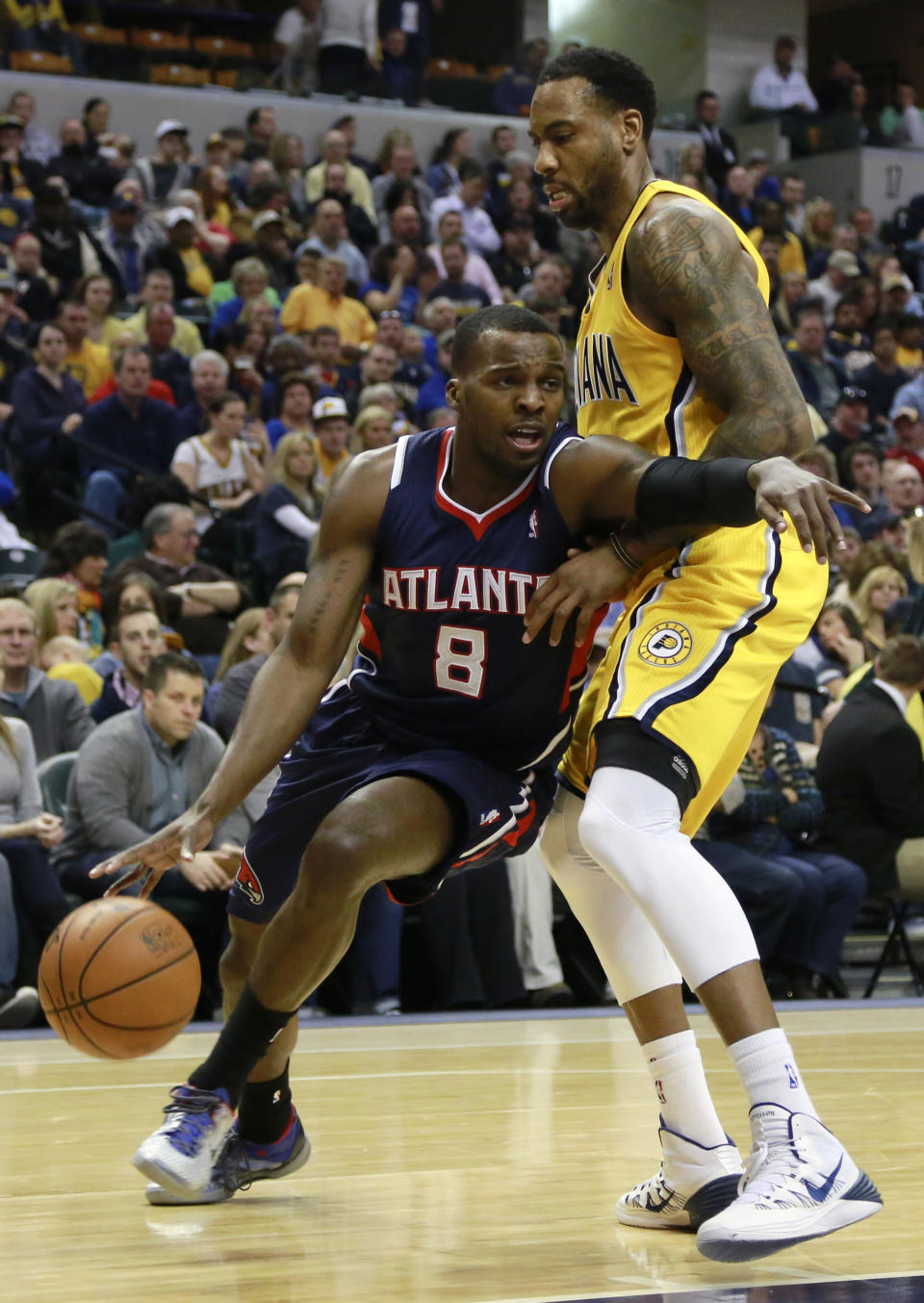 Atlanta Hawks guard Shelvin Mack (8) pushes his way past Indiana Pacers guard Rasual Butler in the first half of an NBA basketball game in Indianapolis, Sunday, April 6, 2014. (AP Photo/R Brent Smith)