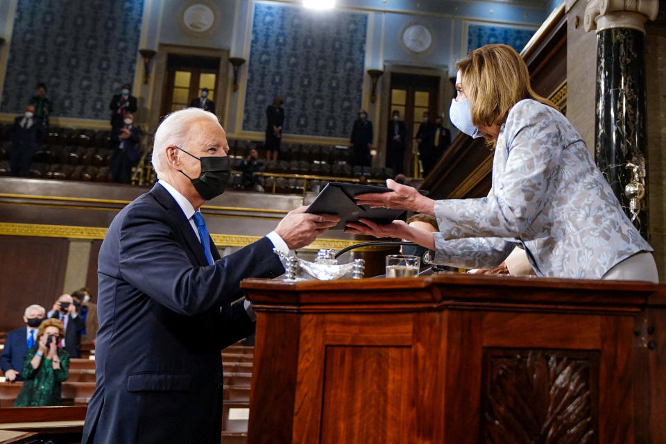 President Joe Biden hands a copy of his speech to House Speaker Nancy Pelosi of Calif., as he arrives to address a joint session of Congress, Wednesday, April 28, 2021, in the House Chamber at the U.S. Capitol in Washington. (Melina Mara/The Washington Post via AP, Pool)