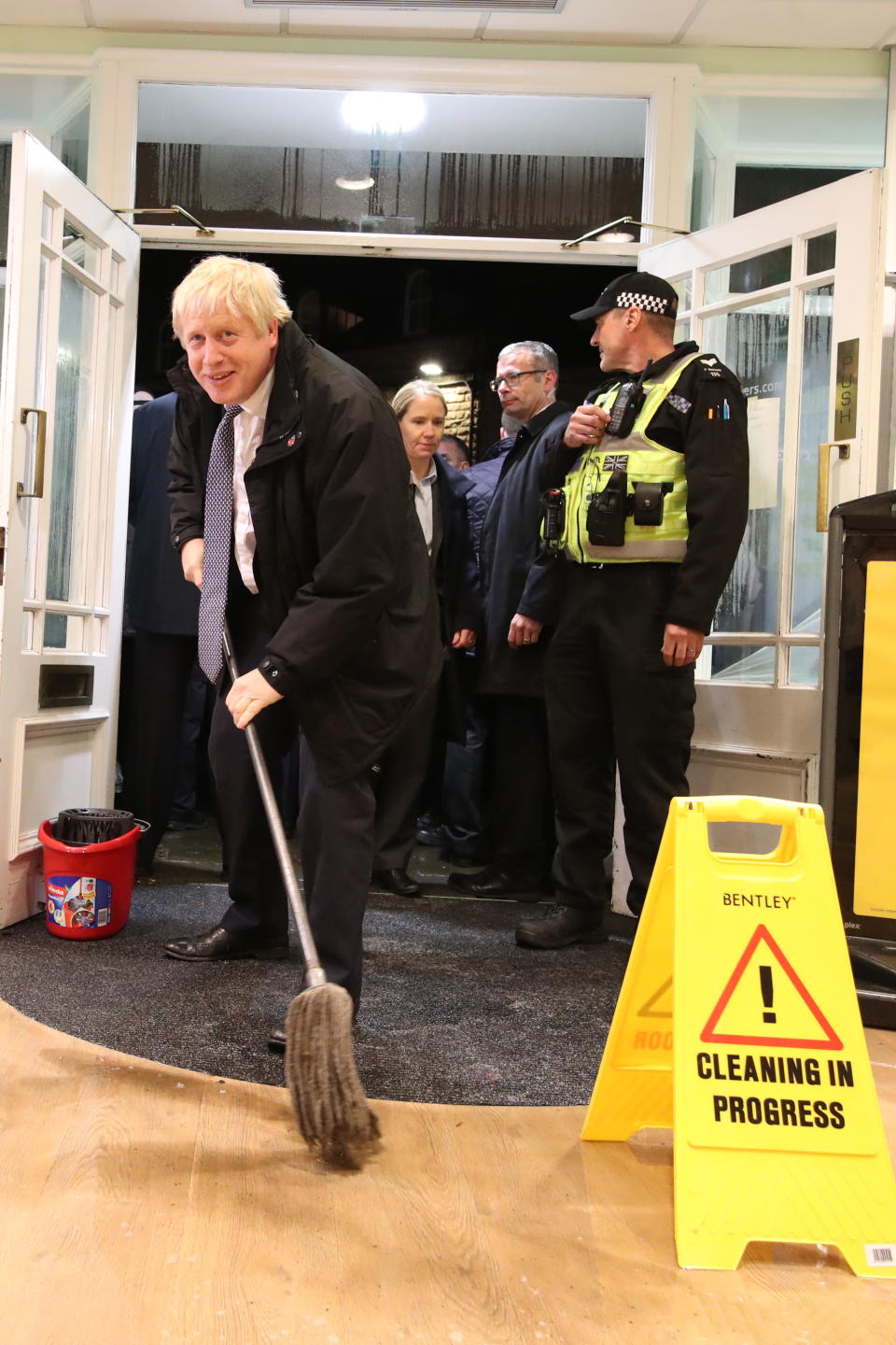 Britain's Prime Minister Boris Johnson helps with the clean up at an opticians in Matlock, northern England, on November 8, 2019 after it was effected by flooding. - Over a month's worth of rain fell on parts of England Thursday, with some people forced to evacuate their homes, and others left stranded in a Sheffield shopping centre. (Photo by Danny Lawson / POOL / AFP) (Photo by DANNY LAWSON/POOL/AFP via Getty Images)