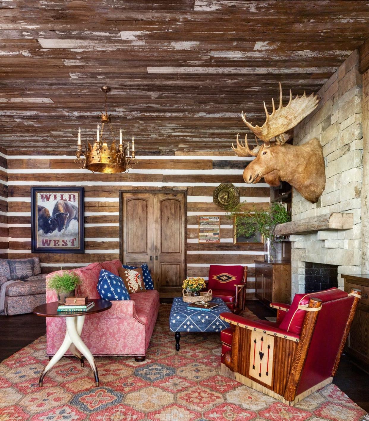 rustic family room with log walls and red upholstered furniture