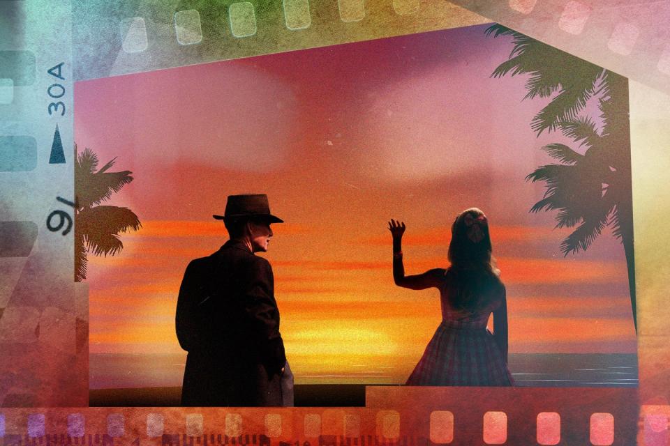 Seen from behind in front of a sunset, Barbie's silhouette waves goodbye as Oppenheimer looks on, hands in pockets. 