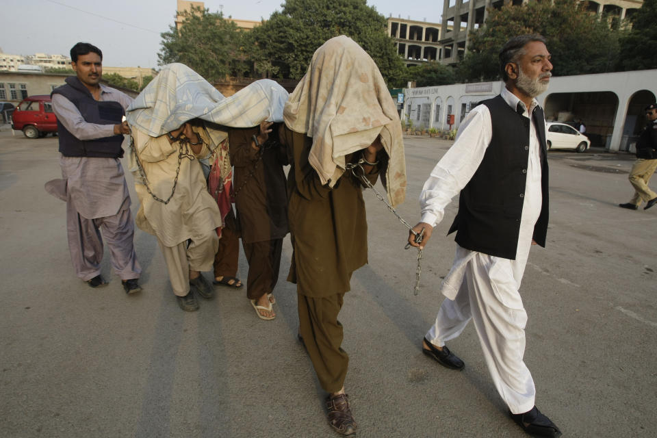 FILE - Pakistani security officials escort alleged militants of Tehreek-e-Taliban Pakistan to anti-terrorist court in Karachi, Pakistan on Thursday, Jan 5, 2012. The Pakistani Taliban, also known as Tehreek-e-Taliban Pakistan, or TTP, claimed responsibility for the Jan. 30, 2023 deadly suicide bombing at a mosque inside a police compound in the northwestern city of Peshawar, in one of the deadliest attacks on security forces in recent months. (AP Photo/Fareed Khan, file)