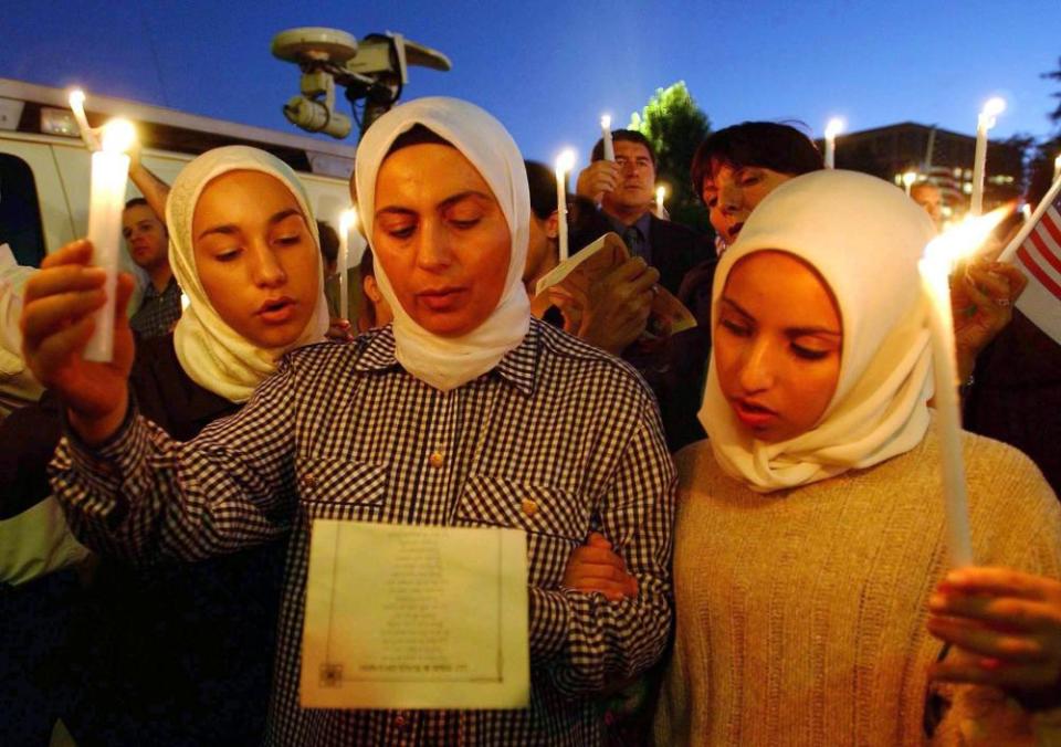Lena Alfi, her mother Manal Alfi and Heba Hathout sing God Bless America on 13 September 2001 in Pasadena, California, at an interfaith memorial service for victims of the 9/11 attacks.