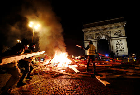 Protesters set fire during a "Yellow vest" protests against higher fuel prices, on the Champs-Elysees in Paris, France, November 24, 2018. REUTERS/Benoit Tessier