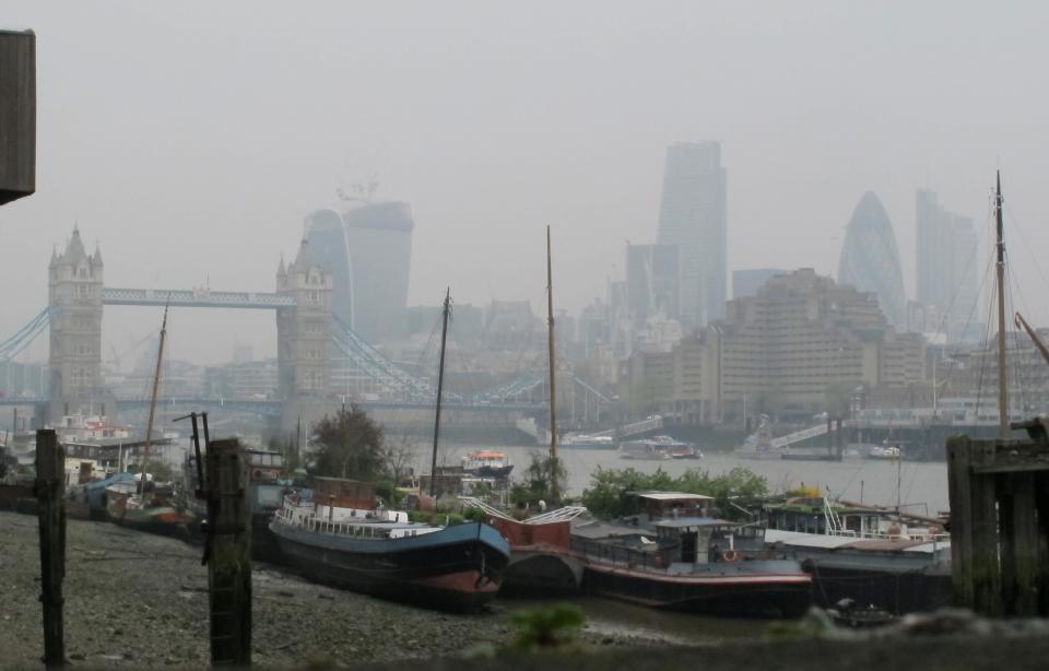 Tower Bridge and the high rise towers of the City of London are shrouded in smog Thursday April 4, 2014. European pollution and dust swirling in from the Sahara has created a "perfect storm" of smog as it continued in Britain on Thursday, prompting authorities to warn people with heart or lung conditions to cut down on tough physical exercise outdoors. (AP Photo/Tony Hicks)