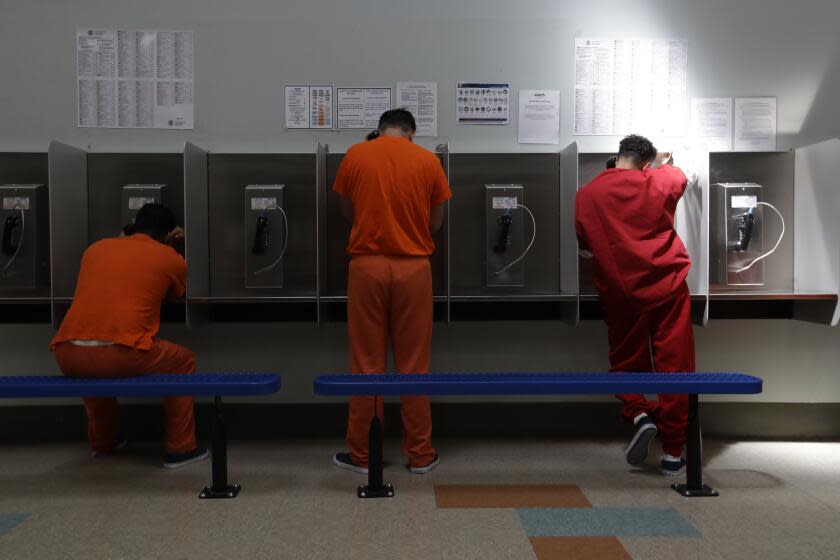 FILE - In this Aug. 28, 2019, file photo, detainees talk on telephones at the Adelanto ICE Processing Center in Adelanto, Calif. The Trump administration has awarded four contracts worth billions of dollars to operate private immigration detention centers in California, less than two weeks before a new state law forbidding them takes effect. (AP Photo/Chris Carlson, File)