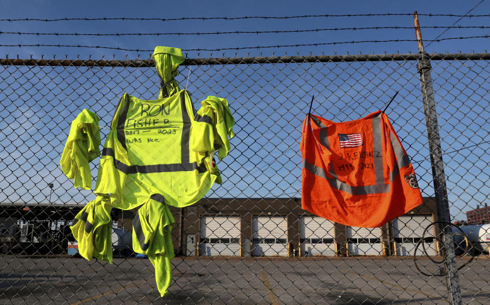 Safety vests for Yellow drivers Ron Fisher and J. Keilholz are zip-tied to fencing at the YRC Freight terminal as it lies closed in St. Louis, on Monday, July 31, 2023. Troubled trucking company Yellow Corp. is shutting down and filing for bankruptcy, the Teamsters said Monday. An official backruptcy filing is expected any day for Yellow, after years of financial struggles and growing debt. (Robert Cohen/St. Louis Post-Dispatch via AP)