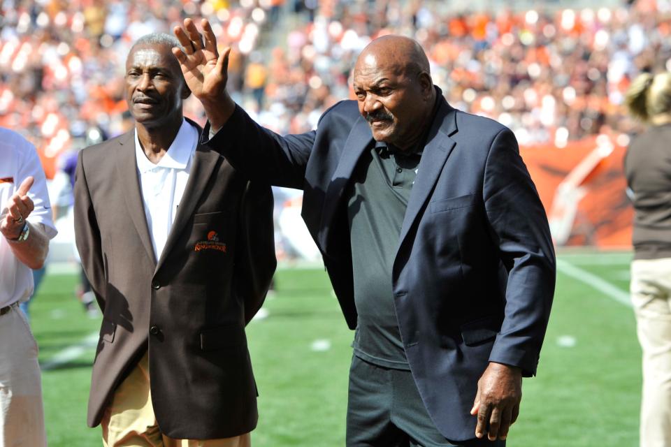 Pro Football Hall of Famers Paul Warfield, left, and Jim Brown stand on the field in a halftime ceremony when the Cleveland Browns hosted the Baltimore Ravens, Sunday, Sept. 21, 2014.