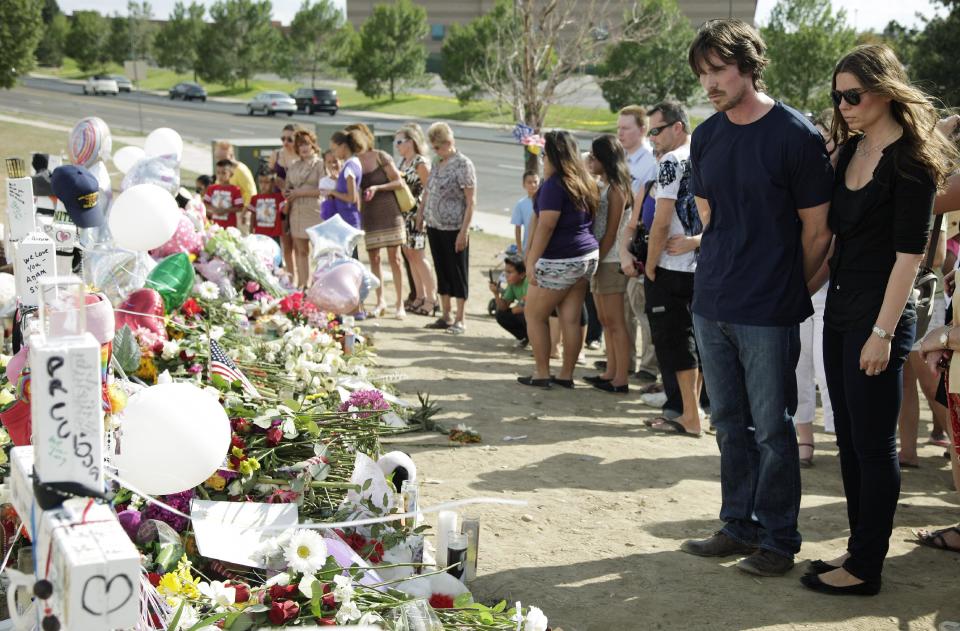 Actor Christian Bale and his wife Sibi Blazic visit a memorial to the victims of Friday's mass shooting, Tuesday, July 24, 2012, in Aurora, Colo. Twelve people were killed when a gunman opened fire during a late-night showing of the movie "The Dark Knight Rises," which stars Bale as Batman. (AP Photo/Ted S. Warren)
