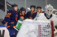 Edmonton Oilers' Leon Draisaitl (29) celebrates his 500th NHL point with James Neal (18), Ryan Nugent-Hopkins (93) and Tyson Barrie (22), during the second period of an NHL hockey game against the Vancouver Canucks on Saturday, May 8, 2021, in Edmonton, Alberta. (Jason Franson/The Canadian Press via AP)