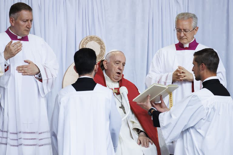 El Papa lee con ayuda durante una misa al aire libre en Edmonton, Canadá