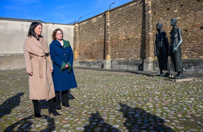 German Foreign Minister Annalena Baerbock (L) visits the Ravensbrueck Memorial and talks to Andrea Genest (R), director of the memorial. The "Women's Group" by artist Will Lammert stands to the right of the Wall. Soeren Stache/dpa