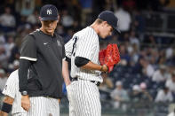 New York Yankees pitching coach Matt Blake, left, has a mound conference with starting pitcher Andrew Heaney, right, in the fourth inning of a baseball game against the Baltimore Orioles, Monday, Aug. 2, 2021, in New York. (AP Photo/Mary Altaffer)