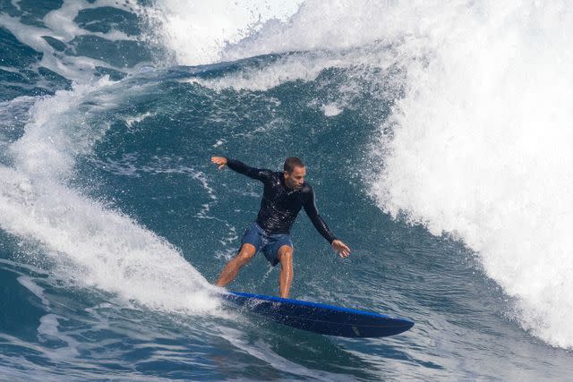 <p>BRIAN BIELMANN/AFP via Getty</p> Jack Johnson surfs ahead of the World Surf League championship events on the North Shore of Hawaii in January 2024.